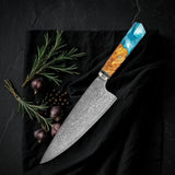 Kiritsuke Kaen 20 cm: cuchillo de chef japonés de lomo recto en acero damasco con mango octogonal de resina turquesa y madera, sobre tela negra con romero