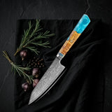 Petty Kaen 9 cm: puntilla japonesa de acero damasco con mango octogonal de resina turquesa y madera, sobre tela negra con romero